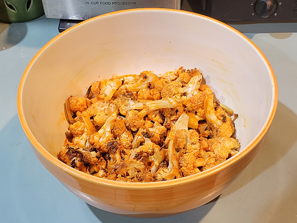 a bowl with light orange cauliflower in the center of it