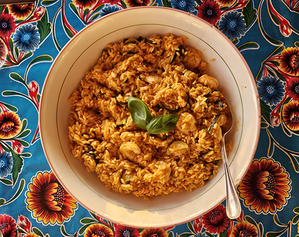 a pot containing pasta on a brightly colored tablecloth